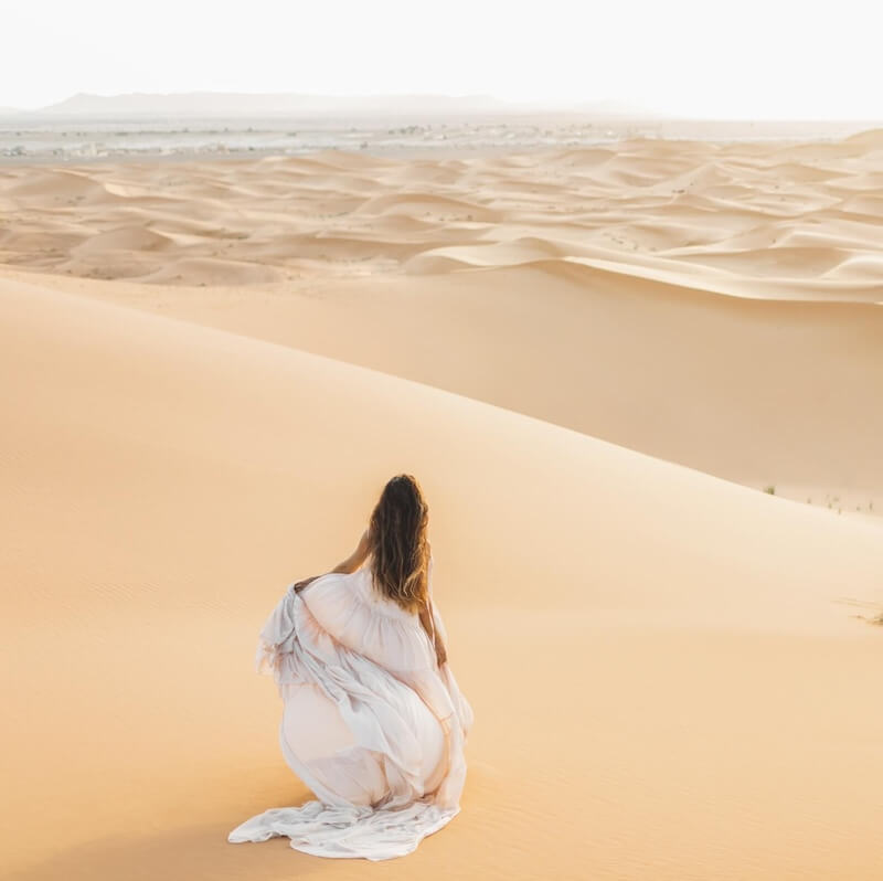 Woman in a white dress in the Sahara Desert in Morocco